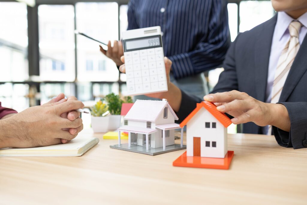 Calculator and house models showing upside down mortgage selling options