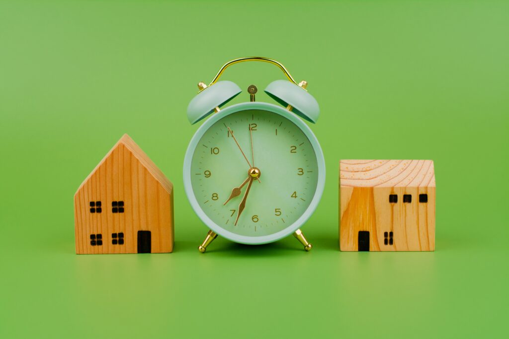 Wooden houses and clock showing fast cash home sale timeline